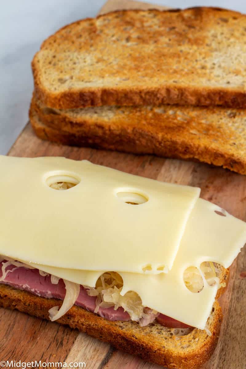 Reuben sandwich being made with corned beef, sauerkraut and swiss cheese 