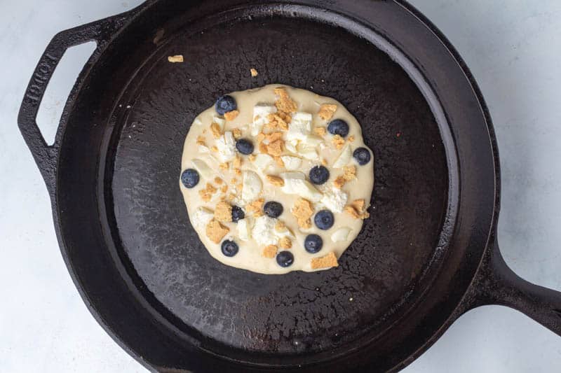 White Chocolate Blueberry Cheesecake Pancakes cooking in a pan on the stove