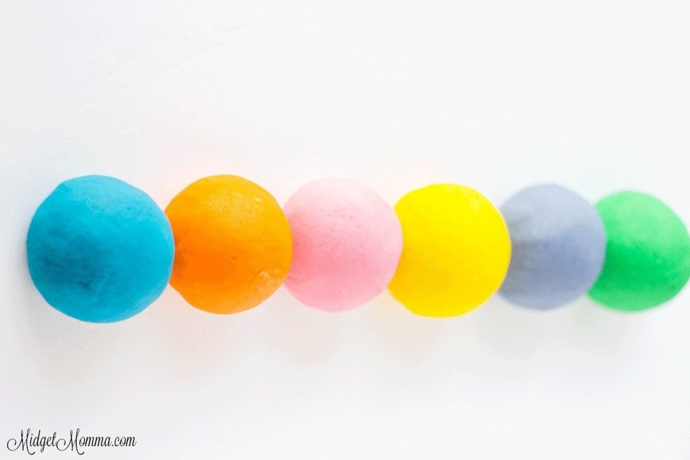 balls of homemade playdough in pink, yellow, purple, orange, blue and green