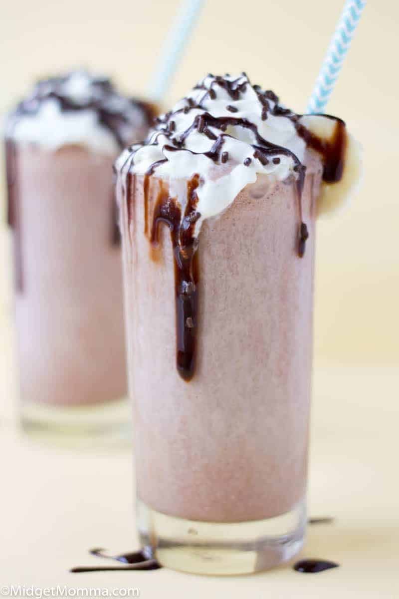 Chocolate Banana Milkshake with whipped cream drizzled with chocolate syrup and chocolate shavings