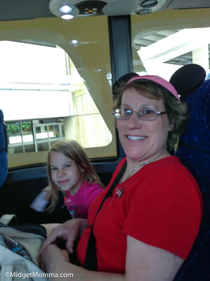Grandma and granddaughter inside a Disney shuttle.