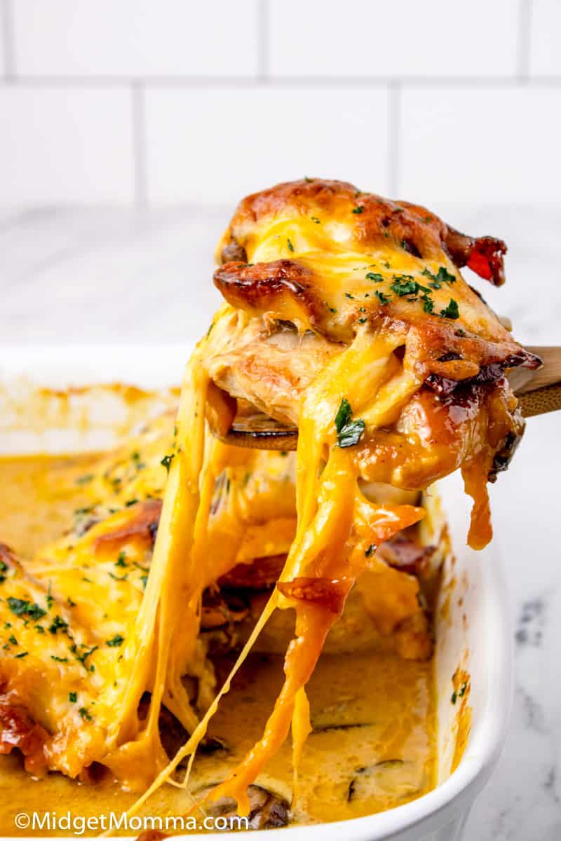 cheesy Alice springs chicken being take out of  the baking dish with a spatula
