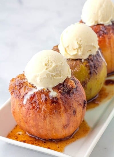 Baked Apples- on a white serving platter topped with vanilla ice cream