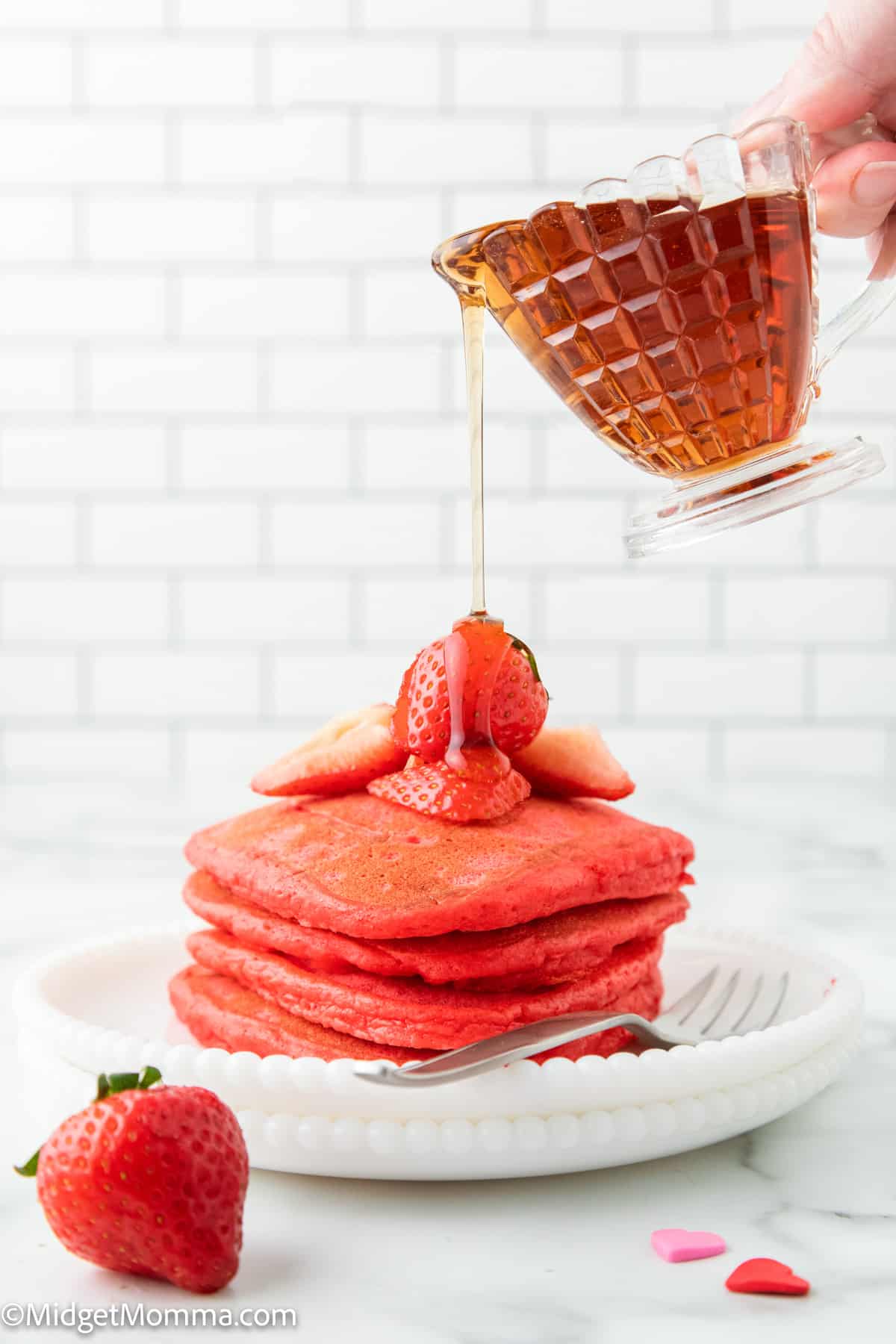 heart pancakes on a plate with a drizzle of maple syrup