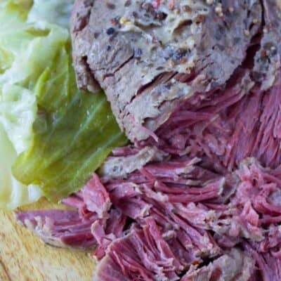 Sliced corned beef and cabbage on a cutting board.