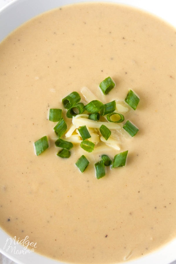 close up photo of a white bowl with cauliflower cheese soup