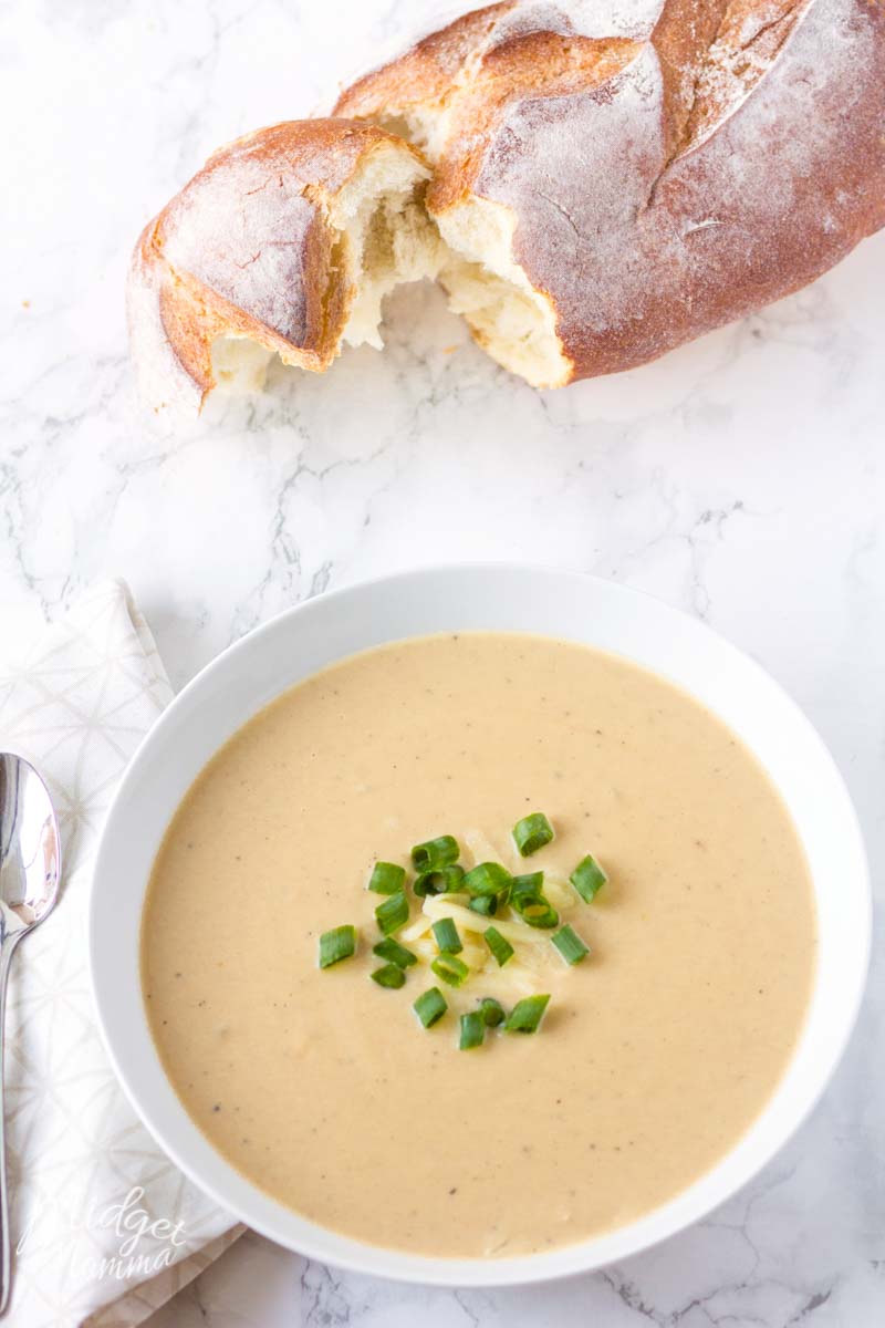 loaf of bread with a bowl of slow cooker cauliflower soup