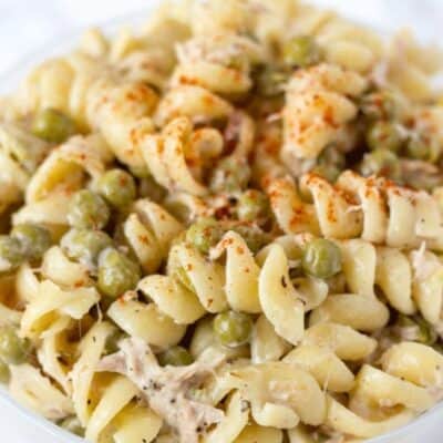 Creamy tuna pasta salad with peas in a bowl.
