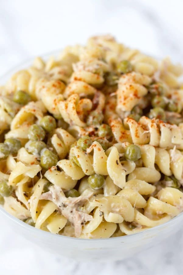 Creamy tuna pasta salad with peas in a bowl.