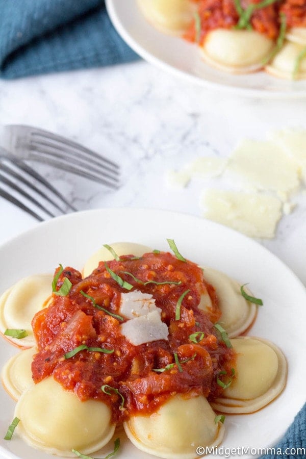 Simple Arrabbiata sauce over ravioli on a white plate with a fork