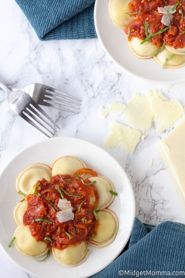 Arrabiata sauce on a white plate over raviolis 