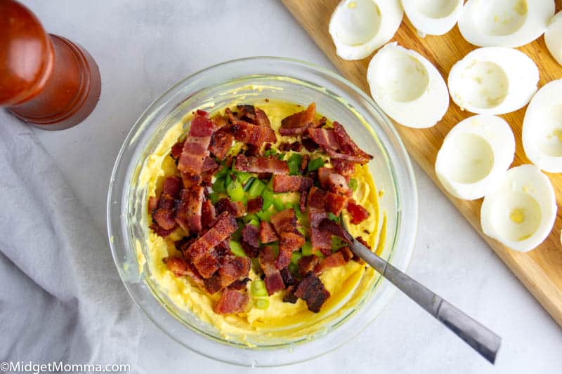 mashed egg yokes, bacon and scallions in a bowl