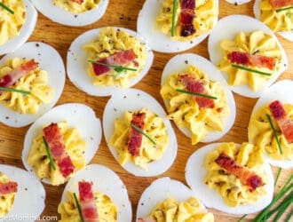 platter of bacon deviled eggs topped with a piece of bacon