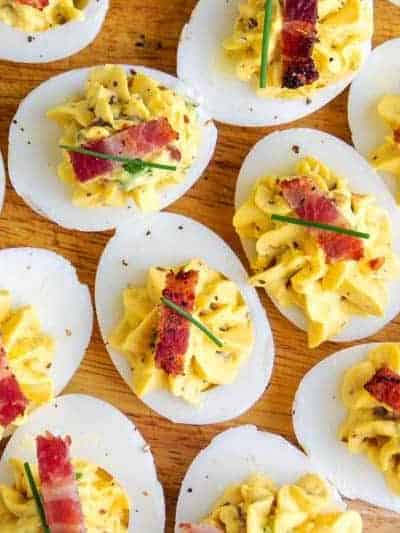 platter of bacon deviled eggs topped with a piece of bacon