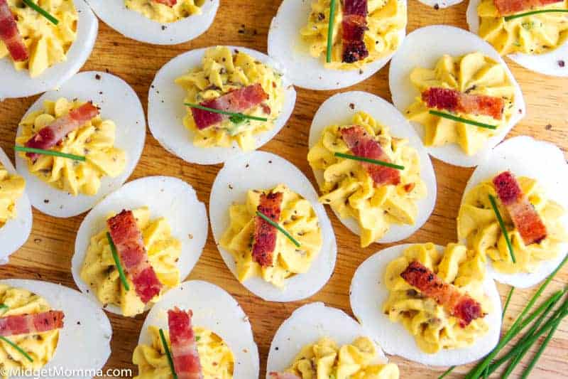platter of bacon deviled eggs topped with a piece of bacon
