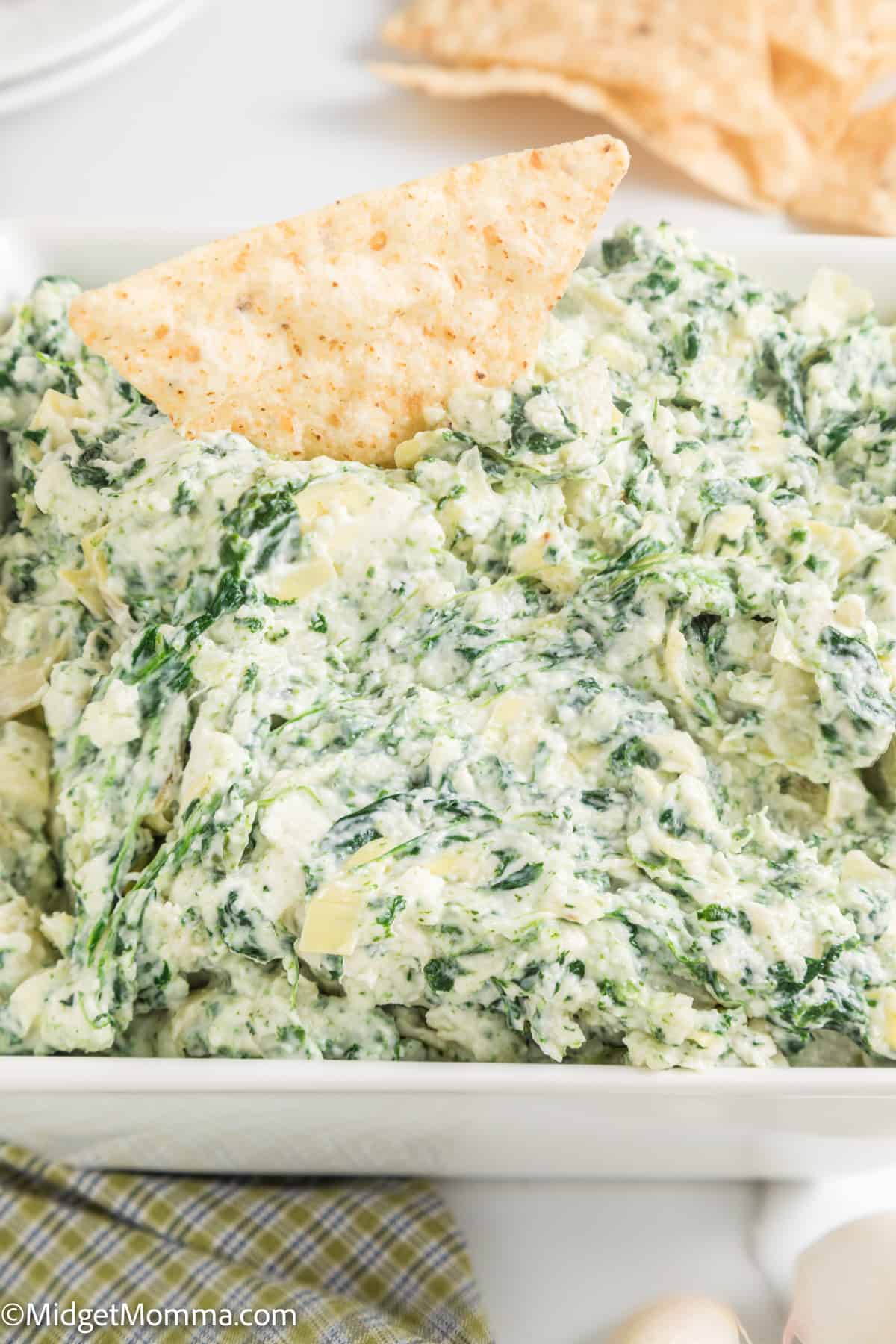 close up photo of Cold Spinach Artichoke dip in a serving dish