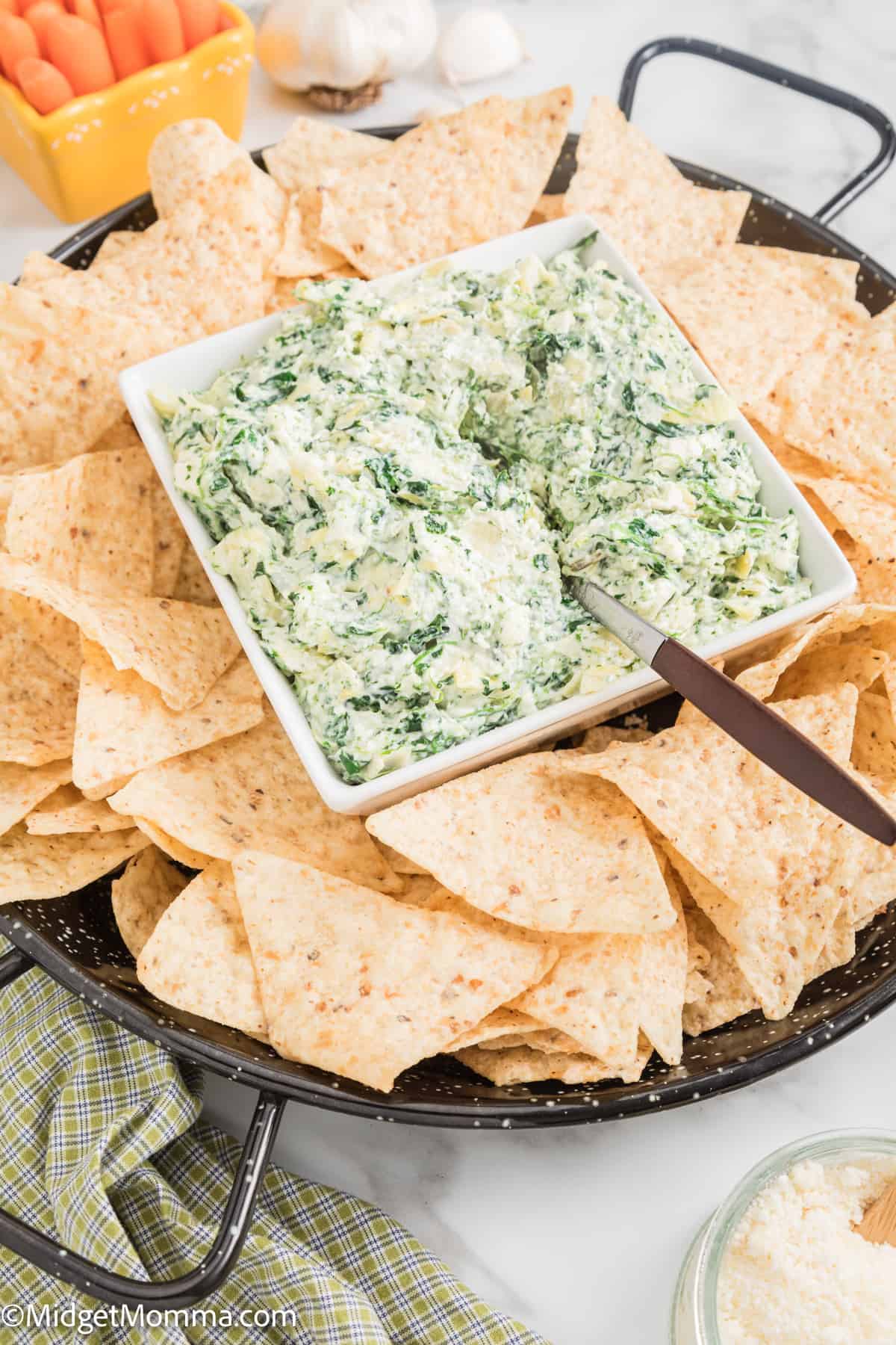 Cold Spinach Artichoke dip in a serving dish with tortilla chips