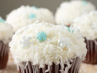 Disney Frozen Inspired Snowball Cupcakes are chocolate cupcake coated in coconut and snow flake sprinkles. Any snowman would love these.