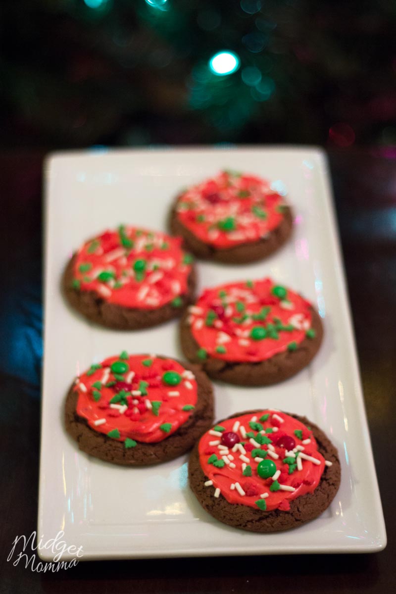 Fresh baked chocolate cake cookies with red frosting and christmas sprinkles