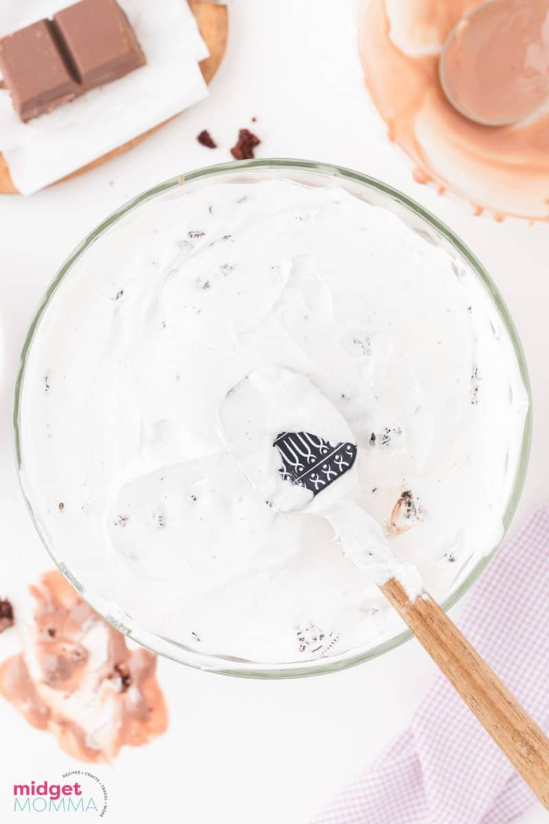 top whipped cream layer being spread on chocolate trifle