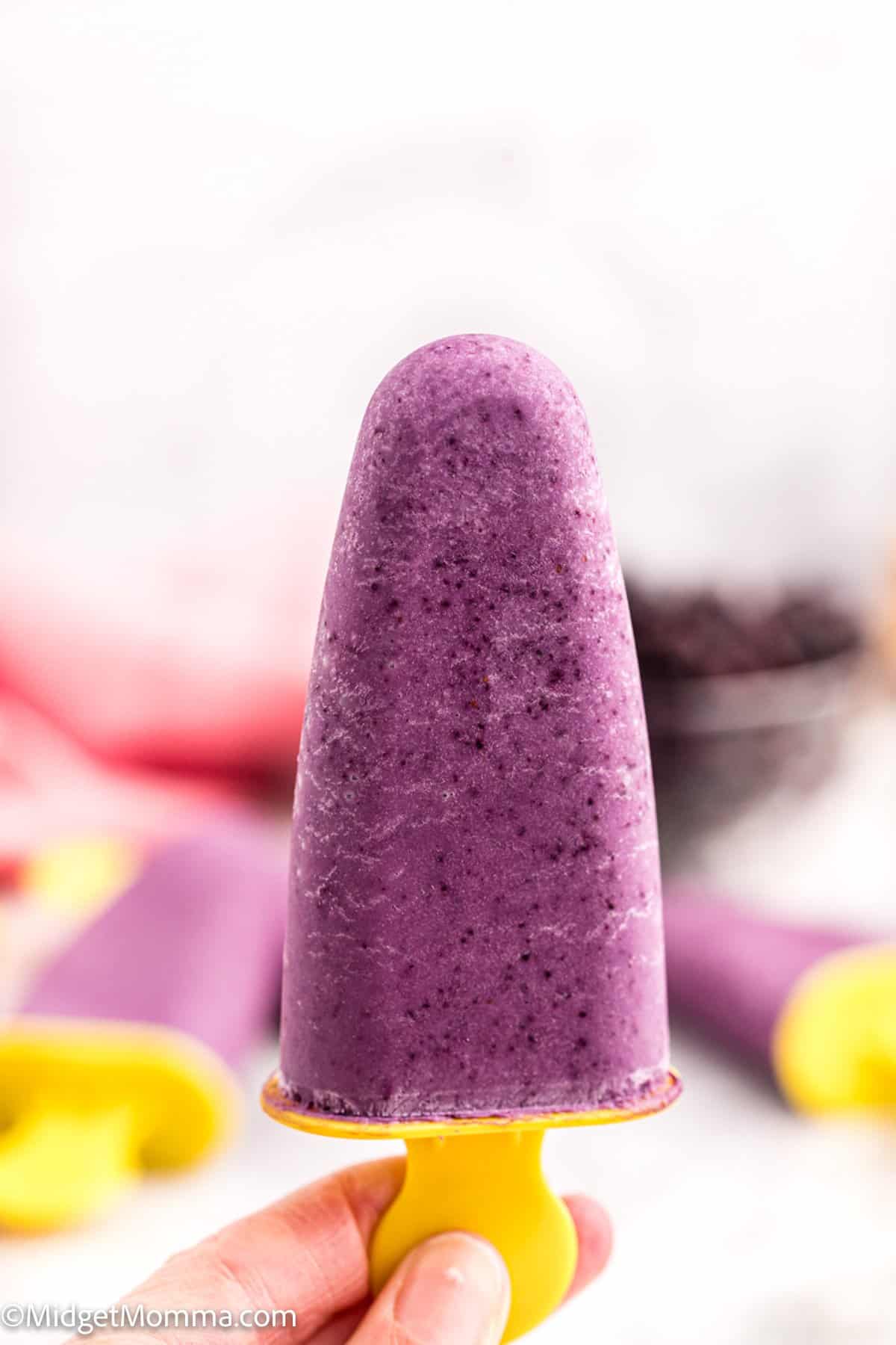 Pineapple Banana Blueberry Yogurt Popsicles being held