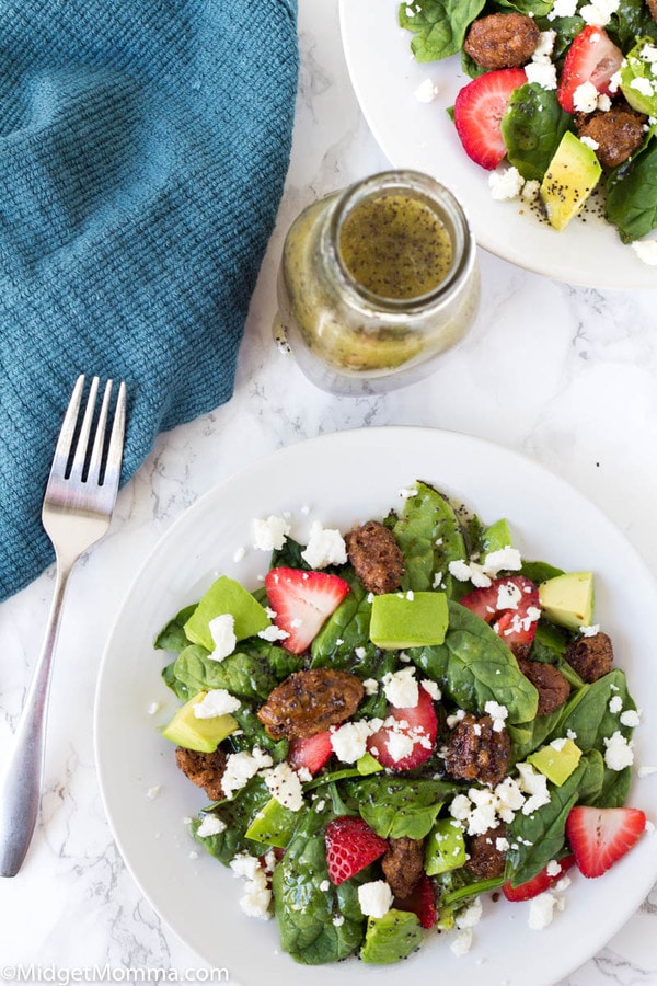 Strawberry Spinach Salad on a white plate with a fork