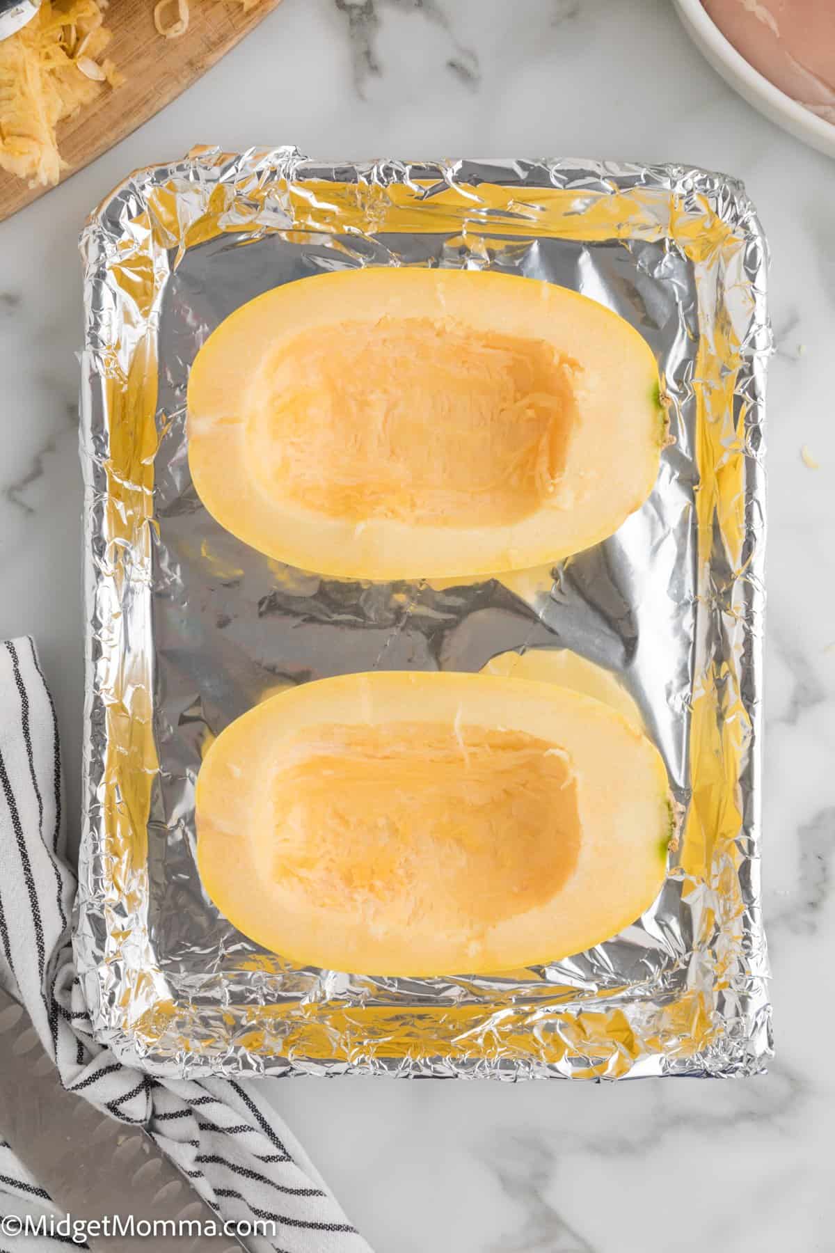 spaghetti squash cut in half on a baking sheet 