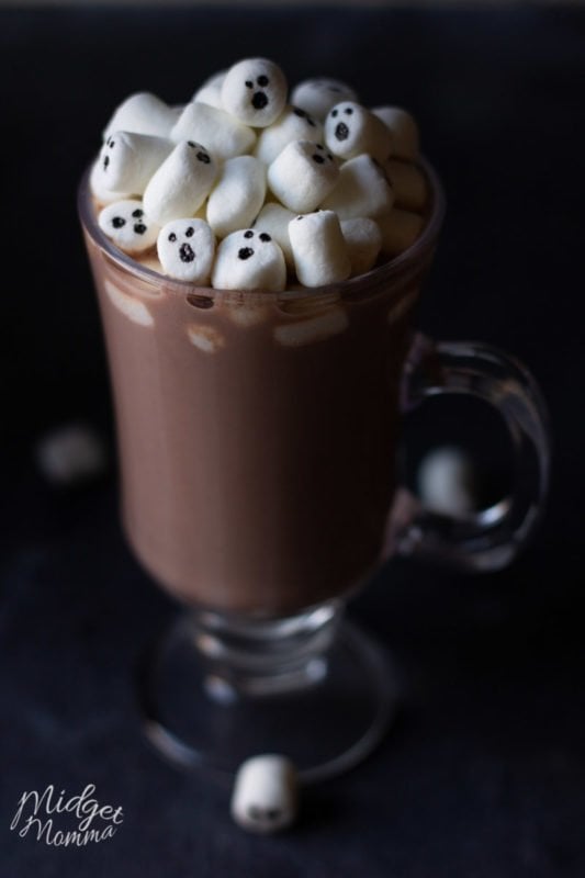 Homemade hot chocolate in a clear mug with marshmallows on top with ghosts faces on them