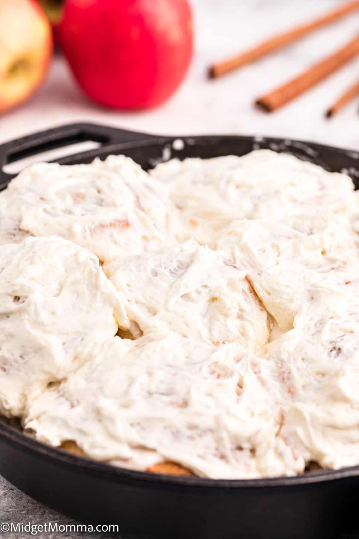 close up photo of Apple Pie Cinnamon Rolls in a cast iron skillet