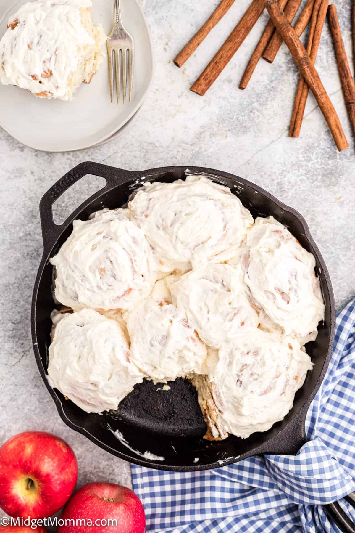 overhead photo of Apple Pie Cinnamon Rolls in a pan with one taken out