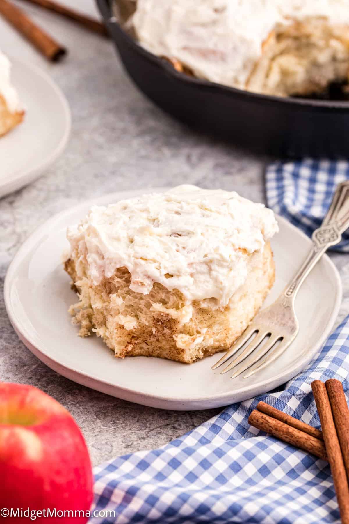 apple pie cinnamon roll on a plate with a fork