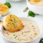 Chicken Pot Pie Soup in a bowl with a biscuit