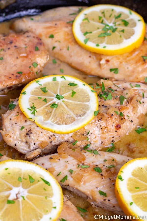 Close up of cooked baked lemon garlic chicken in a skillet