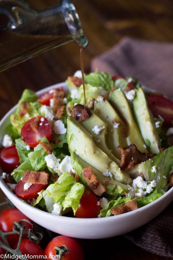 Homemade balsamic dressing being poured on a salad