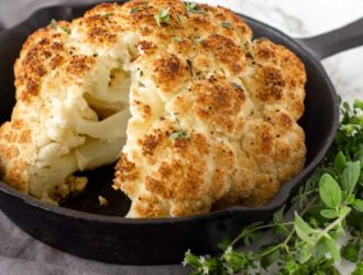 Whole roasted cauliflower in a baking pan