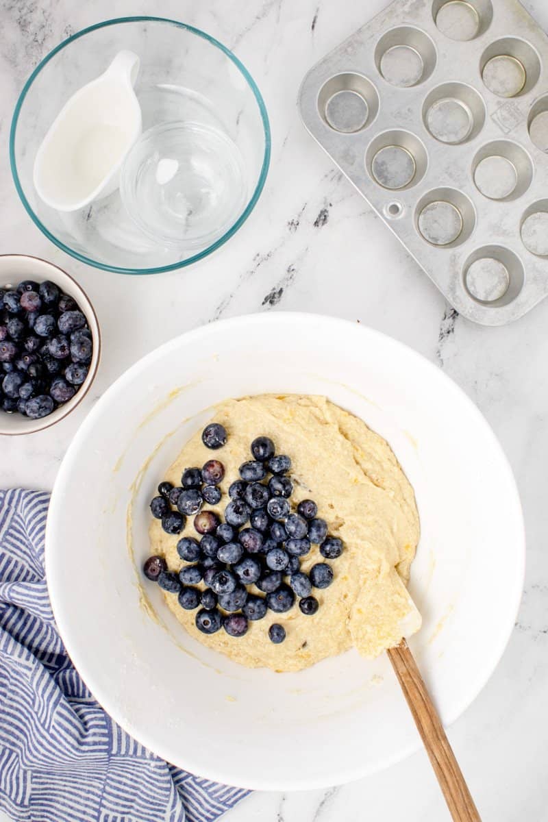 blueberries being added to the muffin mixture