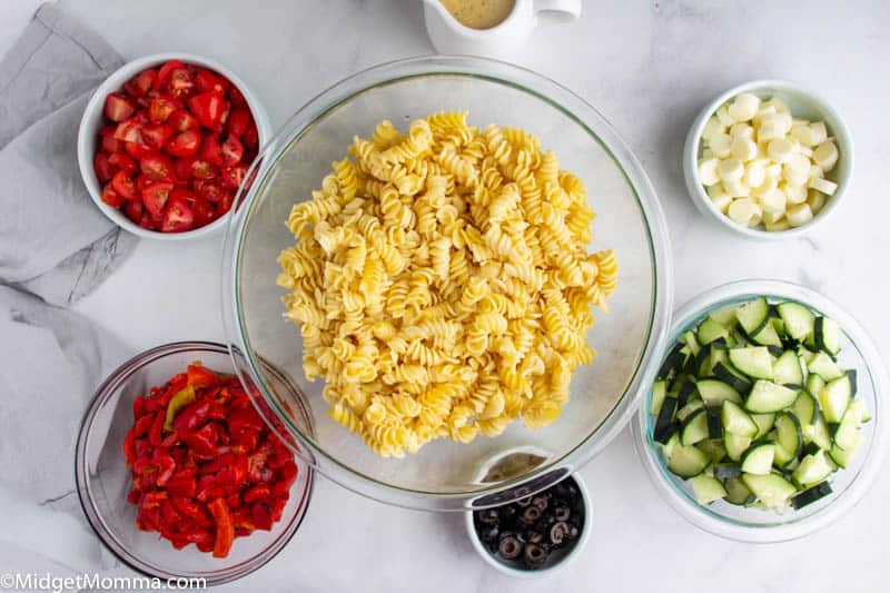 Italian Pasta Salad ingredients in bowls with cooked pasta noodles