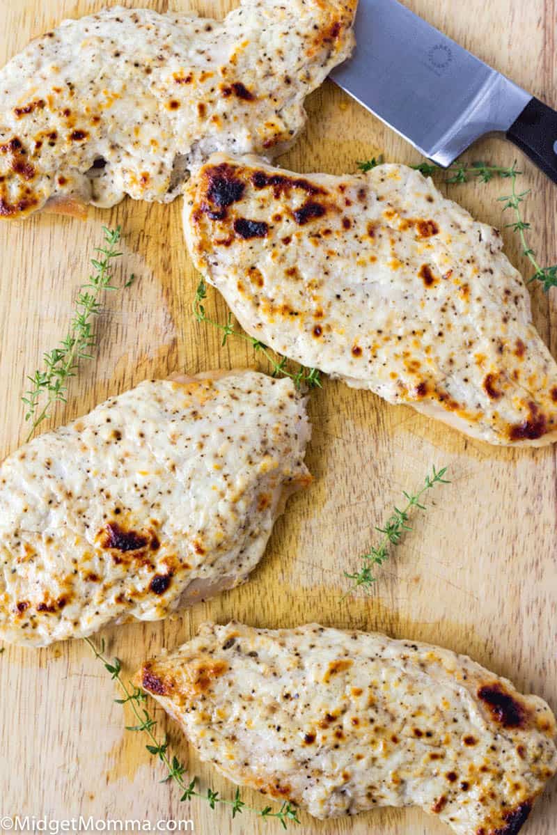 4 pieces of parmesan garlic chicken on a cutting board