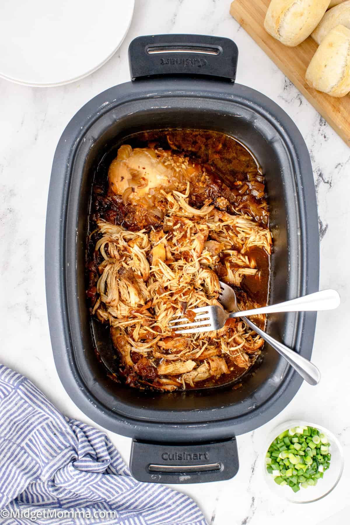 chicken shredded in the slow cooker after being cooked with honey garlic sauce