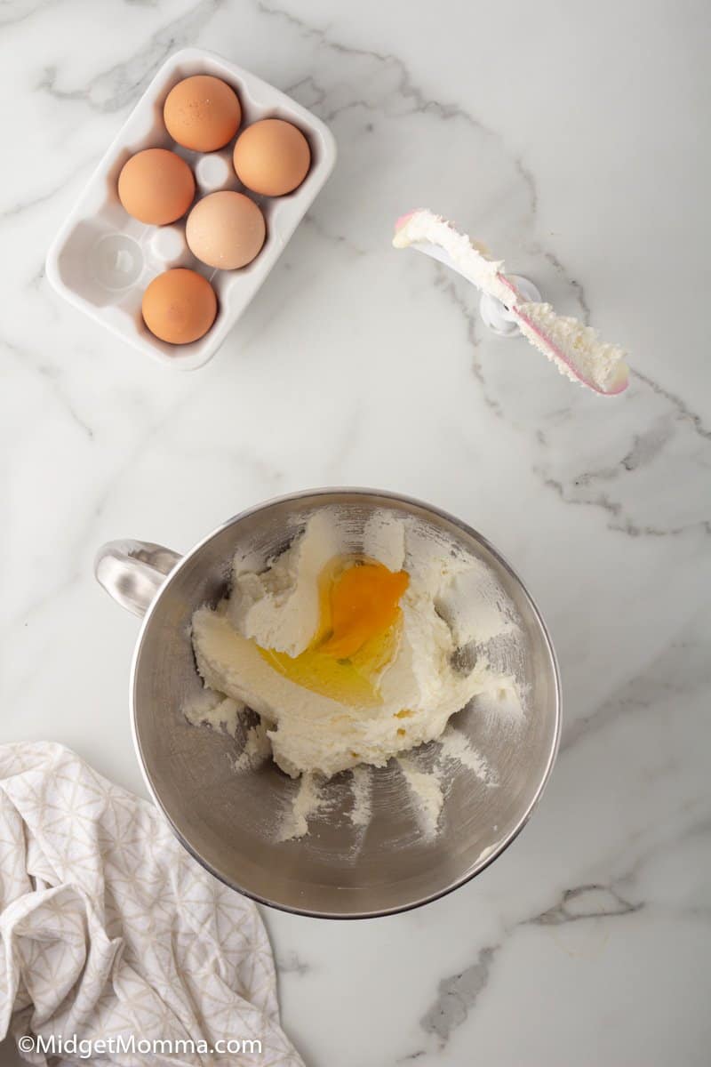 egg added to mixing bowl with butter and sugar