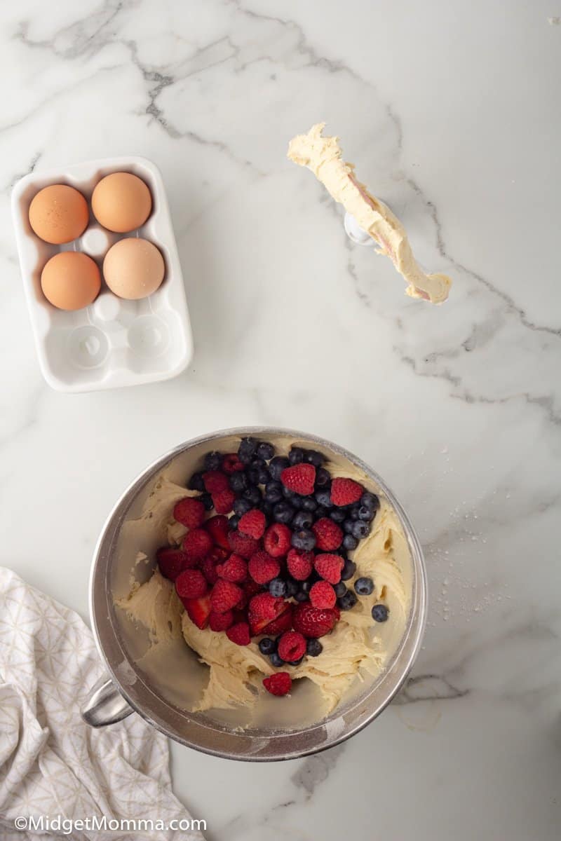 berries added to the muffin mixture in a mixing bowl