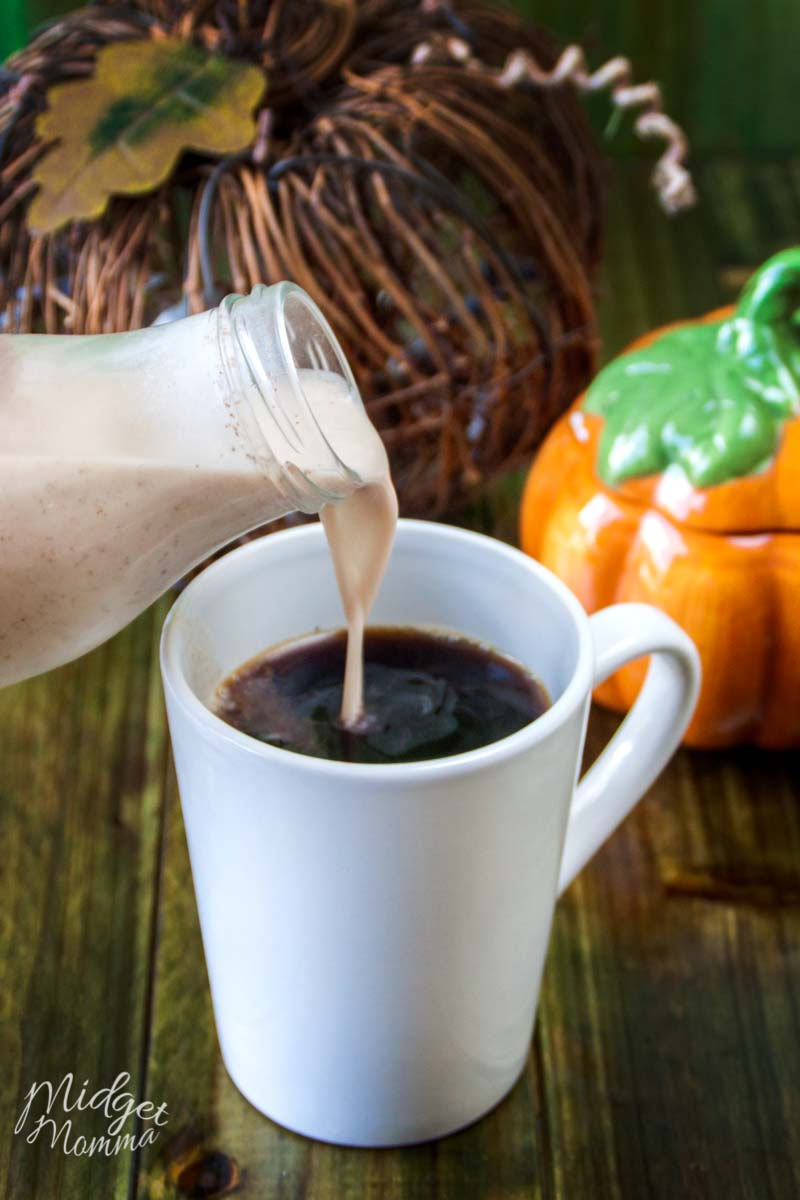 pumpkin spice creamer being poured into a cup of coffee