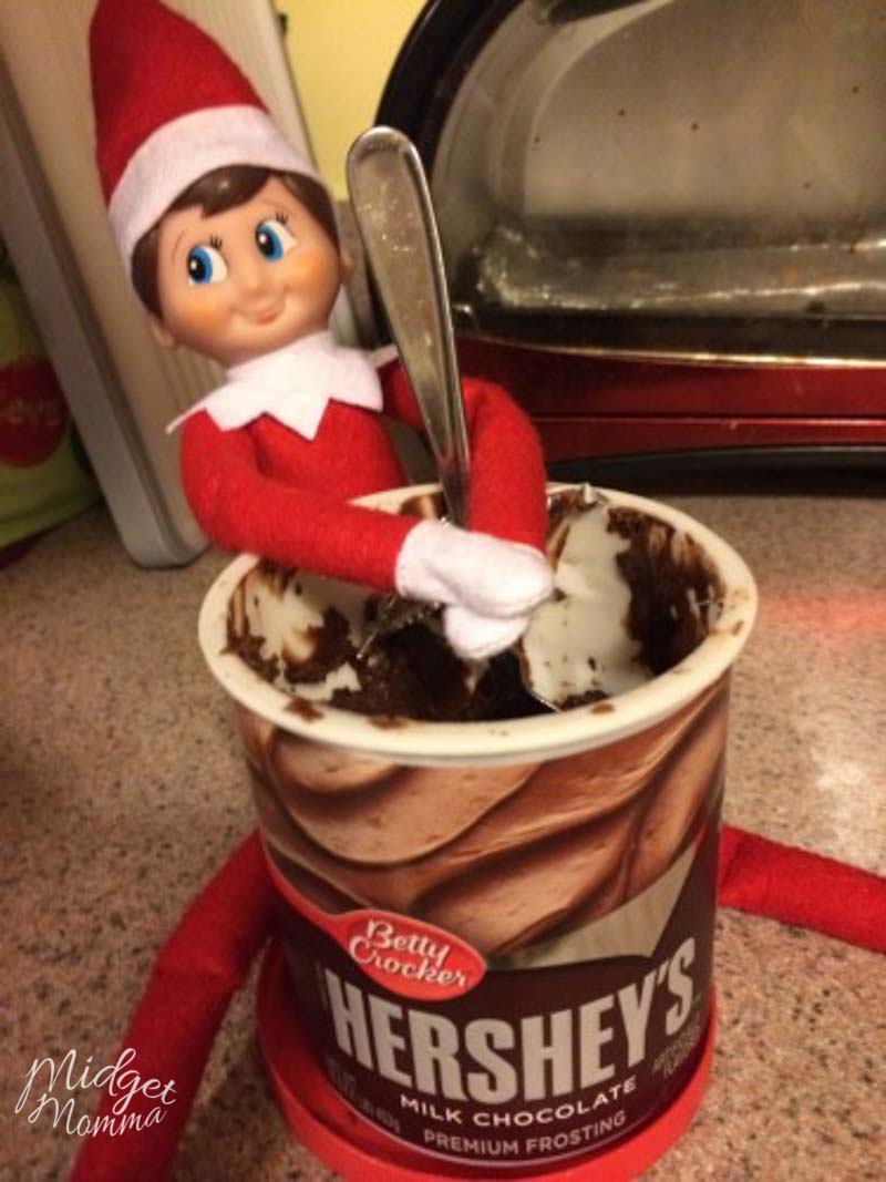 elf on the shelf eating a container of frosting with a spoon