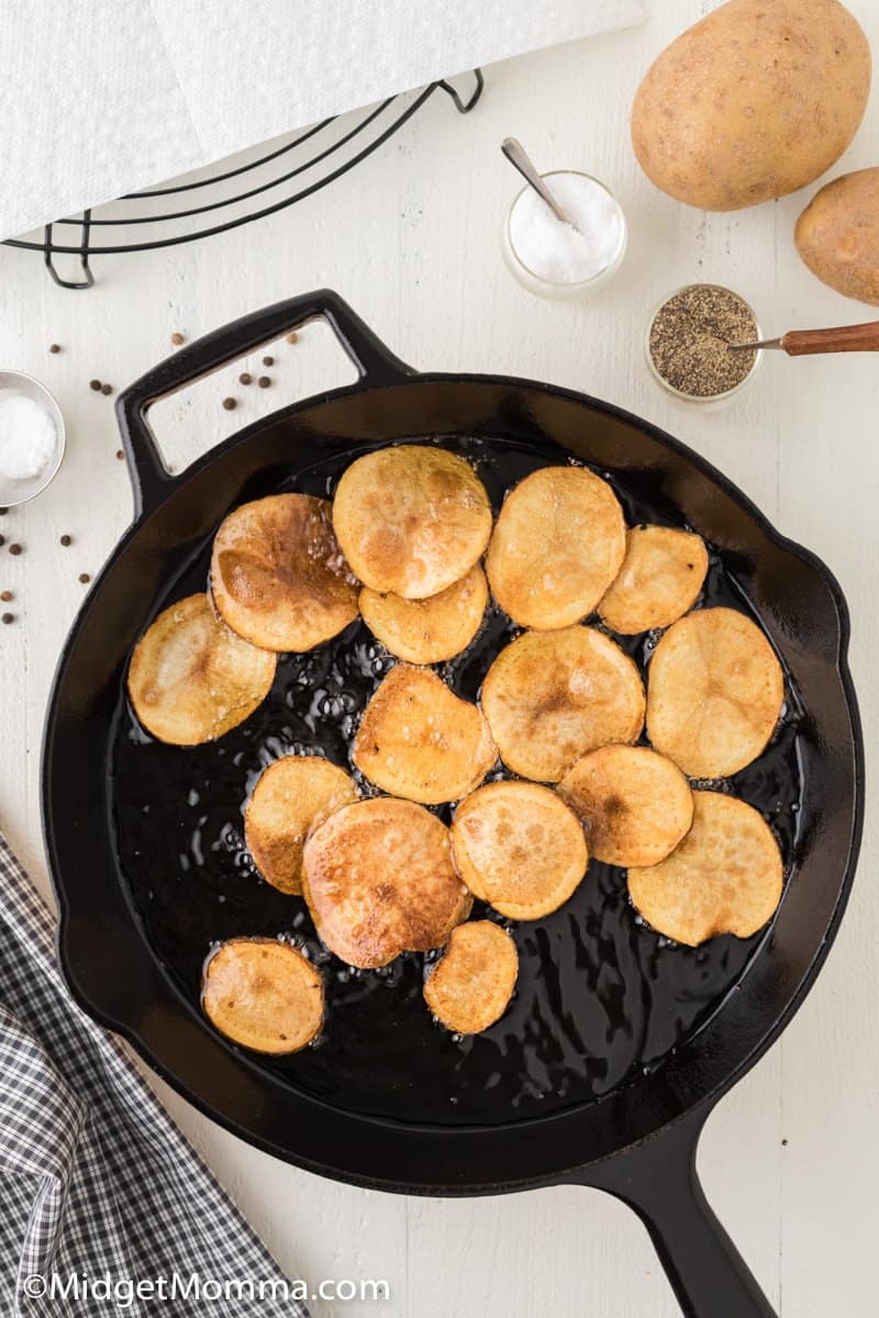 potato chips cooking in a cast iron skillet