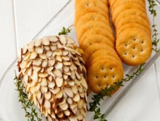 Pinecone cheeseball on a white tray with crackers