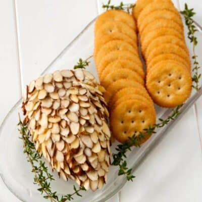 Pinecone cheeseball on a white tray with crackers