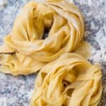 Homemade pasta piles on a cutting board