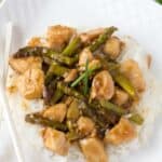 Plate of chicken and asparagus stir fry served over white rice