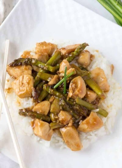 Plate of chicken and asparagus stir fry served over white rice