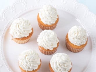 the best vanilla cupcakes topped with vanilla buttercream on a white platter